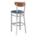 A Lancaster Table & Seating bar stool with a navy cushion and wood back.