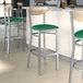 Lancaster Table & Seating Boomerang Series bar stools with green vinyl seats and driftwood backs.