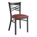 A black Lancaster Table & Seating metal chair with a burgundy vinyl padded seat.