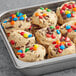 A tray of David's Cookies preformed chocolate chunk cookies with M&M's on top.