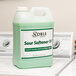 A green liquid container with a white label of Noble Chemical Sour Softener on a washing machine.