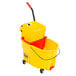 A Rubbermaid yellow mop bucket and red dirty water bucket with side press wringer.