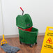 A Rubbermaid green mop bucket with a red dirty water bucket attached.