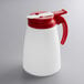 A white Vollrath syrup server with a red lid.