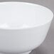 A white GET Water Lily melamine bowl on a gray surface.