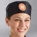 A smiling woman wearing a black Choice cloth chef hat.