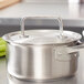 A silver stainless steel Vollrath pot with a lid on a counter.