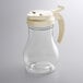 A clear glass Vollrath teardrop syrup server with a white plastic lid.
