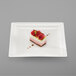 A RAK Porcelain ivory square porcelain plate with a piece of dessert with raspberries on top.