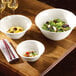 Three ivory RAK Porcelain bowls of salad on a table.