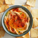 A close up of a bowl of hummus with Regal Smoked Paprika and chips.