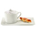 A RAK Porcelain ivory porcelain cup of coffee and a pastry on a plate.