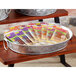 An oval galvanized metal tray with handles holding food on a table.