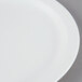 A close-up of a Cambro white polycarbonate plate with a narrow white rim.
