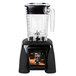 A Waring commercial blender with a black base and clear container on a counter.