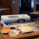 A white Weston Pro-2100 external vacuum packaging machine on a counter with food.