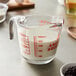 A clear Anchor Hocking glass measuring cup with milk.