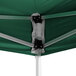 A green tent with black metal poles and metal supports with white fabric.