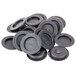 A pile of black round replacement plugs for salt and pepper shakers.