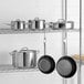 A stainless steel rack holding Vigor SS1 Series stainless steel cookware.