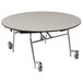 A round white National Public Seating cafeteria table with a black T-mold edge and chrome frame.