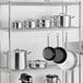 A metal rack with Vigor stainless steel pots and pans.