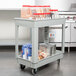 A gray Continental utility cart with food items on it.