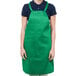 A woman wearing a Chef Revival kelly green apron with one pocket.