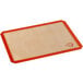 A close-up of a half size orange Mercer Culinary silicone baking mat.