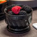 A black Dinex Turnbury insulated bowl filled with blackberries and raspberries.
