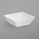 A white Dinex square SAN plastic bowl.