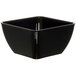 A black square Dinex SAN plastic bowl with a lid on it.