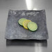 A square Basalt melamine plate with lime slices on it.