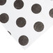 A white paper table cover with black polka dots.