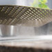 A close-up of a GI Metal gold anodized aluminum pizza peel with a metal surface.