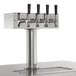 An Avantco black metal beer dispenser with four stainless steel taps.
