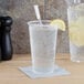 A Dart ClearPro polypropylene cup filled with water, ice, and lemon slices with a straw in it.