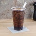 A Dart ClearPro plastic cup filled with soda and ice with a straw.