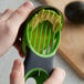 A person using an OXO 3-in-1 Avocado Slicer to peel an avocado in a home kitchen.