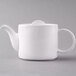 A white Arcoroc stackable teapot with a lid.