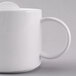 A close-up of a white Arcoroc teapot with a handle.