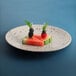 An Elite Global Solutions chocolate chip melamine plate with a watermelon slice and berries on it.