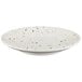 A white Elite Global Solutions round melamine plate with brown speckled spots.
