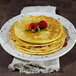 A stack of pancakes on an Elite Global Solutions chocolate chip melamine plate with raspberries on top.