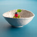 An oval chocolate chip melamine bowl with fruit in it.