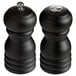 Two black Acopa wooden salt and pepper mills with silver knobs on a counter.