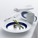 A Schonwald white and dark blue porcelain saucer with a white and blue mug and a plate with asparagus and mushrooms on it.