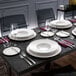 A table set with Villeroy & Boch white bone china plates, silverware, and glasses.