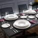 A table set with Villeroy & Boch white bone porcelain plates, glasses, and silverware.