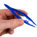 A person's hand holding blue plastic Medi-First tweezers.